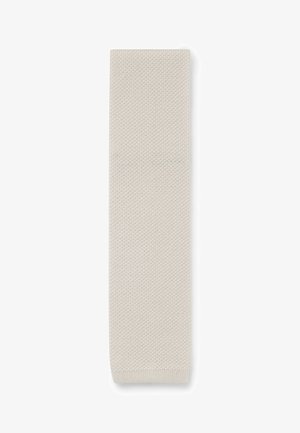 Beige knitted scarf with a textured pattern, rectangular shape, and finished edges, measuring approximately 150 cm in length.