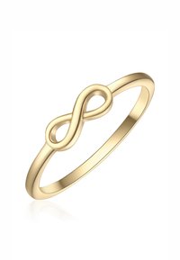 Anillo en tono dorado con diseño de símbolo de infinito, superficie lisa, banda delgada y acabado pulido. Simple y elegante.