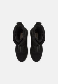 Czarne botki za kostkę z zamszowego materiału, zamek błyskawiczny, puszysta wyściółka wewnętrzna oraz teksturowana gumowa podeszwa.