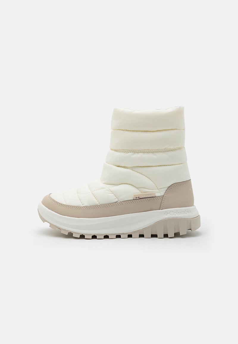 Botim de tornozelo em creme, acolchoado, com sola de borracha bege. Material suave com detalhe acolchoado horizontal e design curvado. Logótipo da marca no calcanhar.