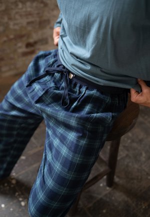Katoenen geruite pyjamabroek in marineblauw en groen met een elastische tailleband en trekkoord. Lichtgewicht stof met een comfortabele, losse pasvorm.