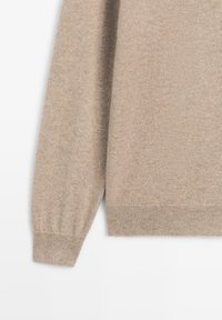 Beige long-sleeve knit sweater sleeve and lower torso section with ribbed cuffs and hem on a white background.