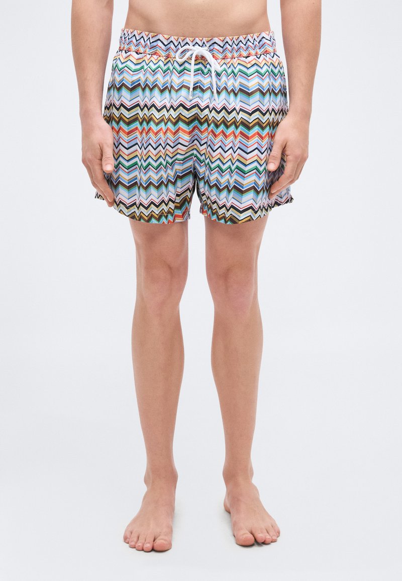 Shorts de bain avec un motif zigzag multicolore aux teintes vives, taille élastique avec cordon de serrage et matière légère.