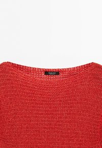 Red loosely knit sweater with a round neckline and a black label reading Massimo Dutti at the back of the collar.