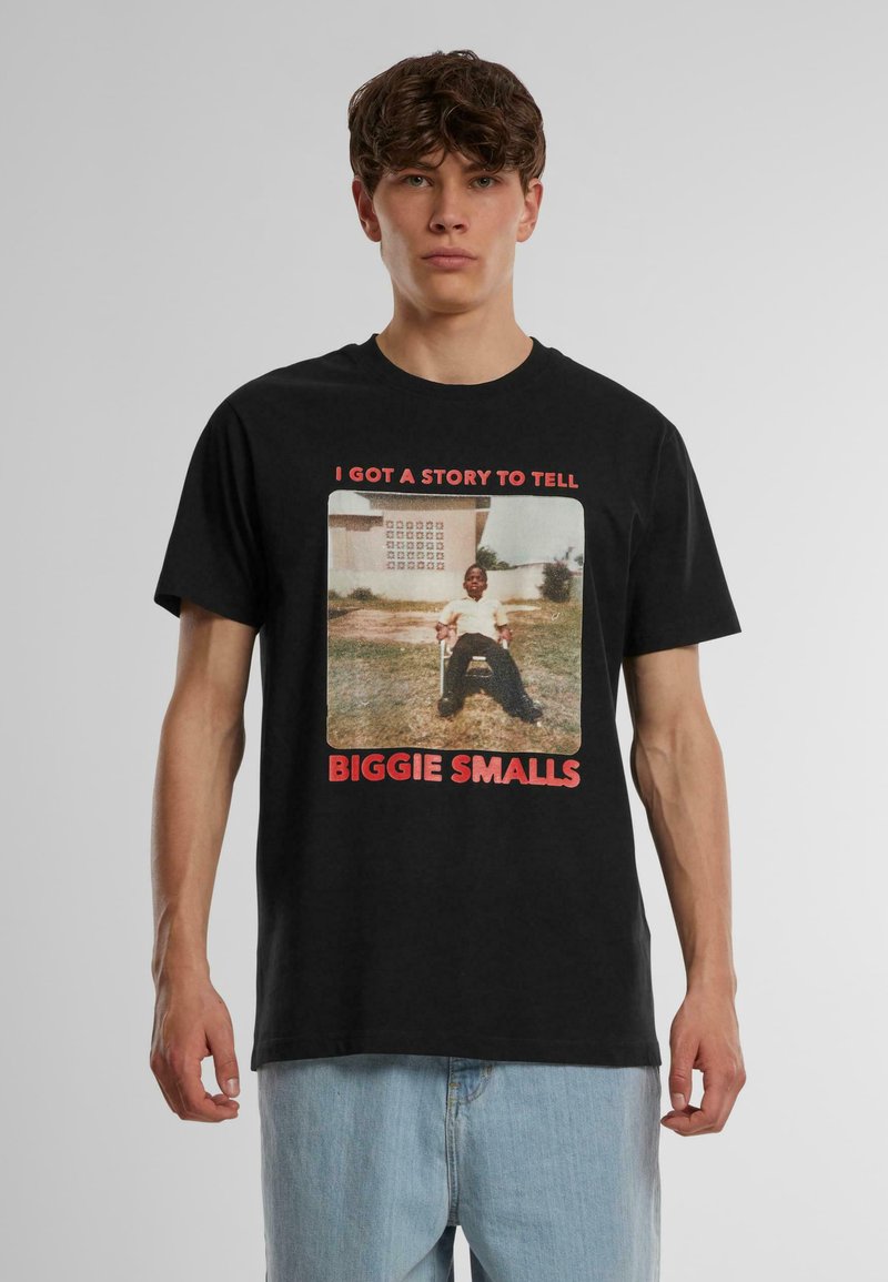 Juodas marškinėliai su rėminta nuotrauka, kurioje matomas žmogus baltais marškiniais, ir užrašu "BIGGIE SMALLS" raudoname tekste. Kasdieniškas modelis.