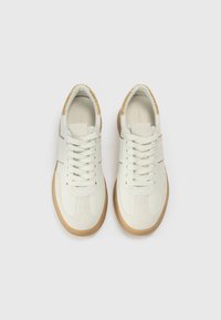 Λευκά αθλητικά παπούτσια με υφή στο επάνω μέρος, που διαθέτουν χρυσή λεπτομέρεια στη φτέρνα, λευκά κορδόνια και λαστιχένια σόλα σε καφέ απόχρωση.