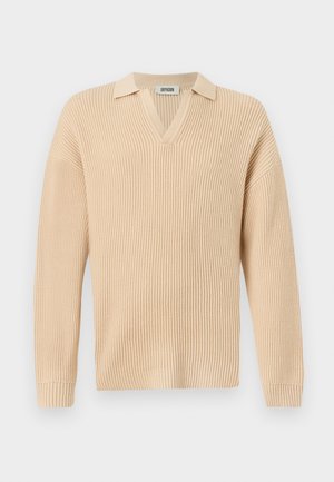 Pull beige côtelé avec un col en V et un col court. Présente une coupe décontractée, des manches longues et un design tricoté texturé sur l'ensemble.