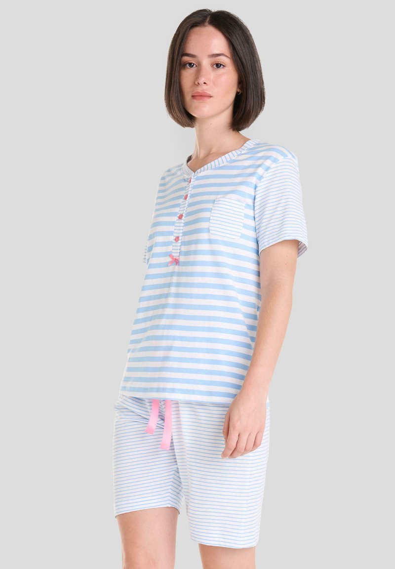 Conjunto de pijama a rayas en azul claro y blanco, que incluye una camiseta de manga corta con un bolsillo y detalle de botones, y pantalones cortos con cordón rosa.