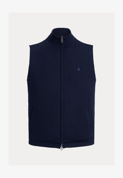 Tumši zila bezvēdera veste ar rāvējslēdzēju, augstu apkakli un smalku izšūtu logotipu kreisajā krūšu daļā.