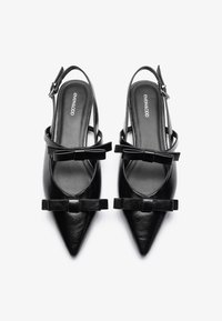 Čierne kožené slingback lodičky s špicatými prstami, ozdobené malými mašličkami na prednej strane. Majú tenký členkový remienok a hladký povrch.