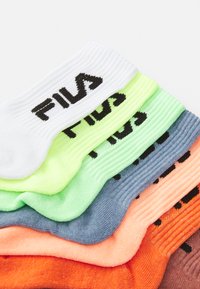 Kuusi paria FILA-sukkia pinoissa, joissa on ribattu pinta. Värit ovat valkoinen, neonvihreä, vaaleansininen, oranssi ja tummanpunainen, mustilla logotunneilla.
