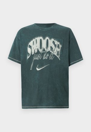 Sötét petrolkék, oversize póló, puha pamutból készült. Nagy grafikai nyomattal rendelkezik, rajta a "SWOOSH" és a "just do it" felirat fehér színben. Klasszikus környakú kialakítás.