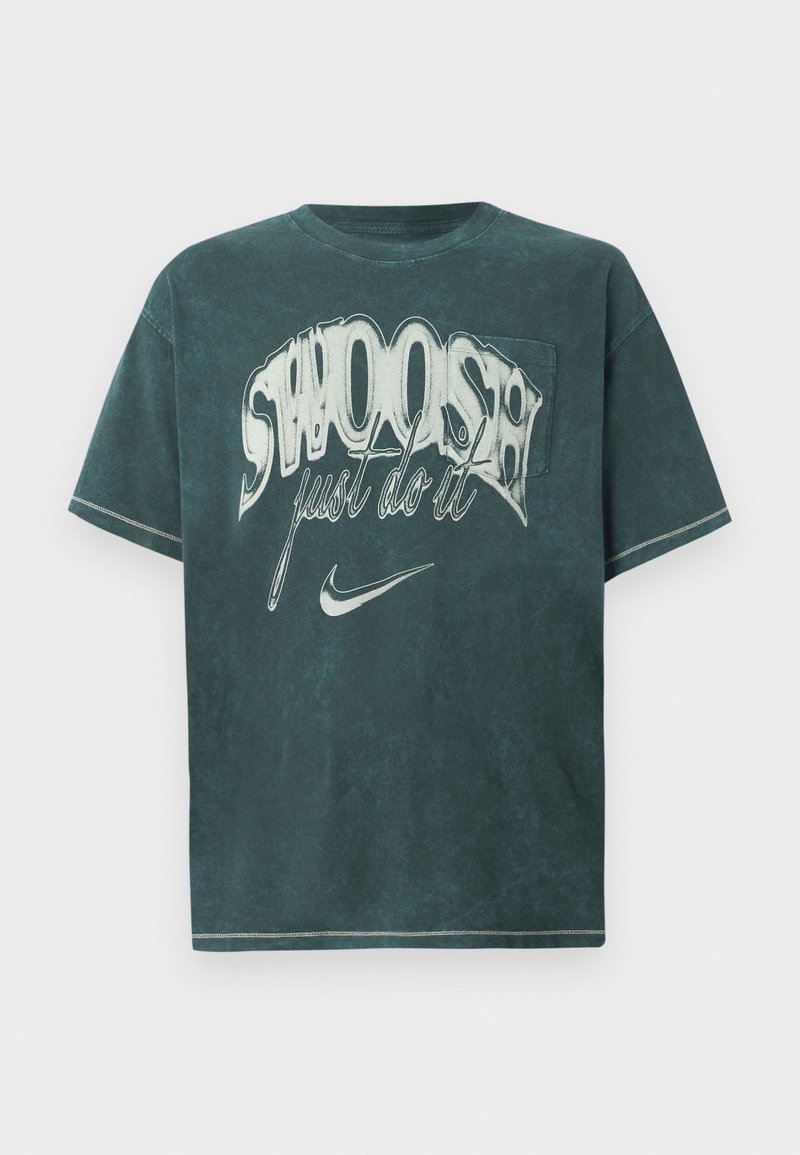 Dunkelblau-grünes übergroßes T-Shirt aus weichem Baumwollmaterial. Mit einem großen grafischen Druck, der "SWOOSH" und "just do it" in Weiß zeigt. Klassisches Rundhals-Design.