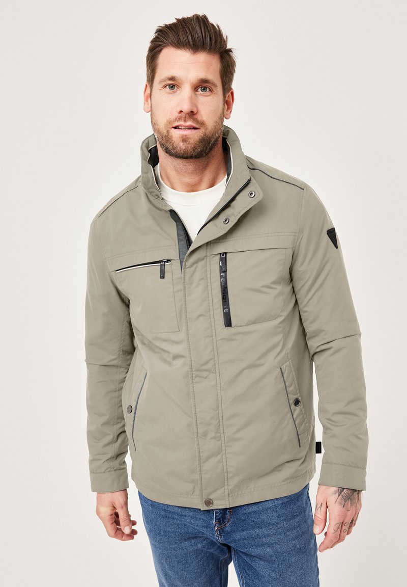 Light grey zip-up jacket with a high collar, two side pockets, a chest pocket, and black accents. Crafted from a smooth, durable fabric.