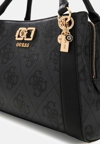 Zwarte synthetische handtas met geperst logopatroon, gouden hardware-accenten, dubbele bovenhandvatten en ritssluiting met sierlijke bedels.