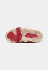 Raudonas ir kremas visos sneaker'io padas turi bangavimo tekstūrą ir rombo raštą su logotipu centre ir išdėstytais gumos elementais.