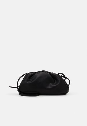 Sort blød lædertaske med opsamlet top og tynd justerbar skulderrem på ensartet lys baggrund.