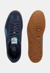 Zapatillas de deporte en azul marino y azul claro, con materiales de ante y malla, cordones planos, suela de goma y detalles de diseño en la suela.