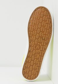 Suela de zapato de goma con un patrón marrón texturizado, borde blanco y sutiles acentos laterales amarillos. Talla 37 indicada en la suela.