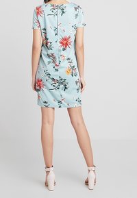 Květinová šatová šaty z lehké modré látky, s krátkými rukávy, kulatým výstřihem, uzavřením na knoflíky na zádech a přiléhavým střihem.