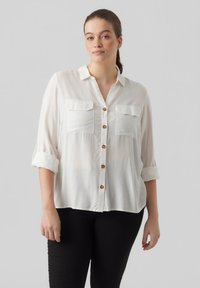 Witte blouse met knopen en opgerolde mouwen, twee borstzakken en goudkleurige knopen, gemaakt van een lichtgewicht, soepel materiaal.