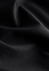 Juodas satino audinys su lygiu paviršiumi, pasižymintis minkštais, lengvai krentančiais klostėmis ir subtiliu blizgesiu, su smulkiais briaunuotais raštais.