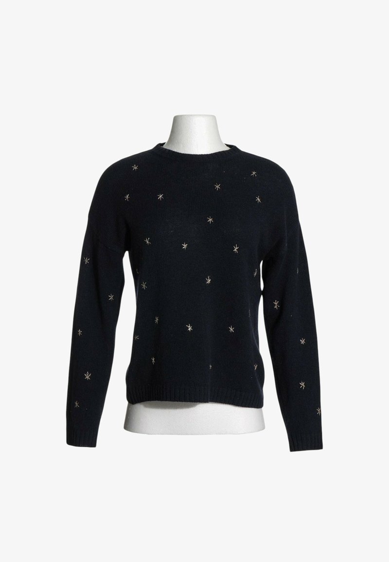 Pull noir à manches longues avec de petites décorations argentées en forme d'étoile dispersées sur le devant et les manches sur un buste de mannequin blanc.