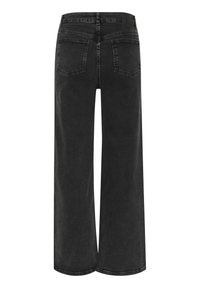 Laiad mustad denim püksid, millel on kulunud tekstuur, kaks tagapool asuvat taskut ja vöölipp. Kanga struktuur on tugev ja järelikult juhuslik.