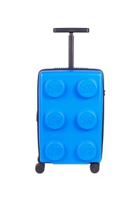 Blue hard-shell suitcase with LEGO brick design, featuring raised circular elements and a retractable black handle on top. Two wheels.