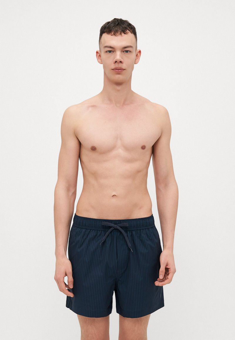 Pantaloni da bagno blu navy con righe verticali, cintura elastica con cordoncino, lunghezza a metà coscia, texture liscia.