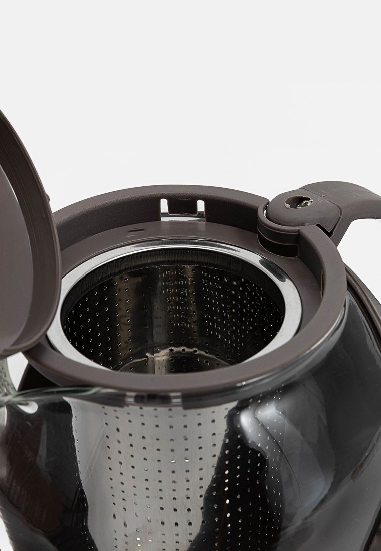 Bouilloire noire avec un corps en verre transparent, un infuseur en métal et un couvercle en plastique marron. Présente un design élégant et une forme ronde.