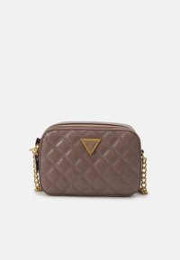 Mała brązowa pikowana skórzana torba crossbody z złotym łańcuszkiem i trójkątną plakietką z logo Guess z przodu.
