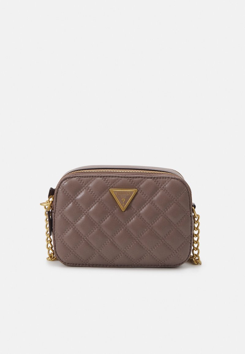 Mała brązowa pikowana skórzana torba crossbody z złotym łańcuszkiem i trójkątną plakietką z logo Guess z przodu.