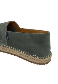 Espadrilla verde in suede con suola in juta intrecciata e accenti cuciti. Presenta una parte posteriore aperta e una forma rotonda, offrendo un design casual.