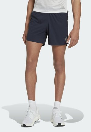 Navy athletic shorts with a textured fabric, elastic waistband, and silver Adidas logo on the left side. Paired with white athletic shoes.