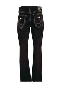 Jeans de mezclilla negra acampanados con costuras blancas en contraste, bolsillos con acentos curvados y un parche con el logo en la cinturilla.