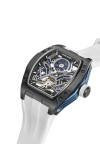 Črno-modna ura z okostnjaki na številčnici, belim silikonskim trakom in teksturirano ohišjem. Ponaša se z avtomatskim mehanizmom in izrazitim gumbom za nastavitev časa.