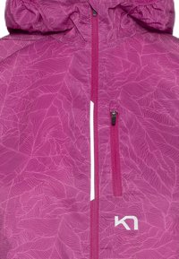 Roze jas met een loofpatroon, voorzien van een volle ritssluiting, een capuchon en een klein zijvak. Het logo is weergegeven in het wit.