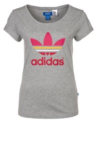 Grå kortärmad t-shirt i bomull med rund halsringning. Har en rosa och gul Adidas-logotyp med tre ränder ovanför texten.