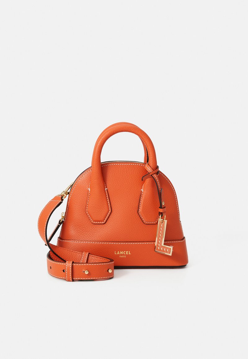 Orange leather handbag with dual top handles, adjustable strap, visible stitching, a gold hardware tag, and Lancel logo on the front.