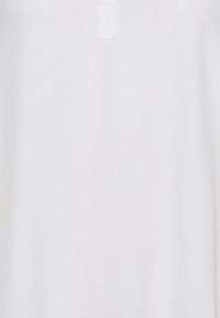 Biała, gładka bluzka z tkaniny z małym zapięciem na guziki przy szyi oraz subtelną fakturą, bez wzorów i dodatkowych dodatków.