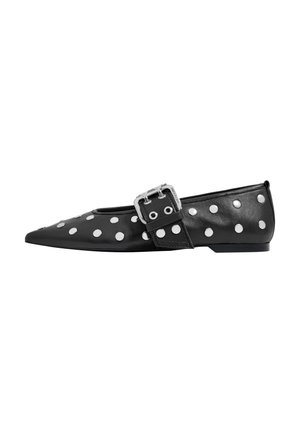 Black leather flat shoe with a pointed toe design, featuring white polka dots and a silver buckle accent on the strap.