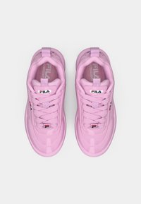 Rosa Sneaker aus glänzendem Material, mit Schnürdesign und gepolstertem Kragen. Auffälliges Fila-Logo auf der Zunge, leichte Sohle und strukturierte Schnürsenkel.