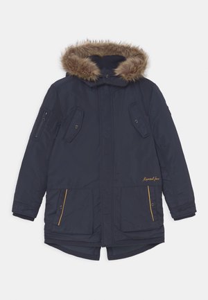 Parka blu navy imbottita con cappuccio foderato in pelliccia sintetica, tasche laterali con zip e dettagli gialli. Presenta una chiusura a scatto e polsini a coste.