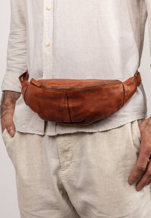 Borsa a tracolla in pelle marrone con una forma curvata e una cerniera metallica. Indossata in vita, presenta una superficie liscia e cuciture minime.