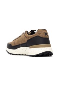 Zapatilla marrón con parte superior de ante y acentos negros, suela de goma texturizada y mediopie beige con detalles salpicados.