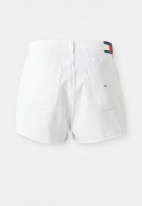 Hvite denimshorts med høy midje og baklommer. Har et lite fargerikt logomerke på midjebåndet. Glatt tekstur.