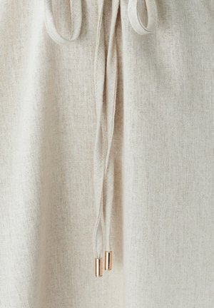 Beżowa tkanina lniana o strukturalnym weżu, z wiązanymi sznurkami i metalowymi końcówkami w kolorze różowego złota dla detalu.