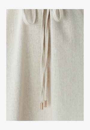 Beżowa tkanina lniana o strukturalnym weżu, z wiązanymi sznurkami i metalowymi końcówkami w kolorze różowego złota dla detalu.