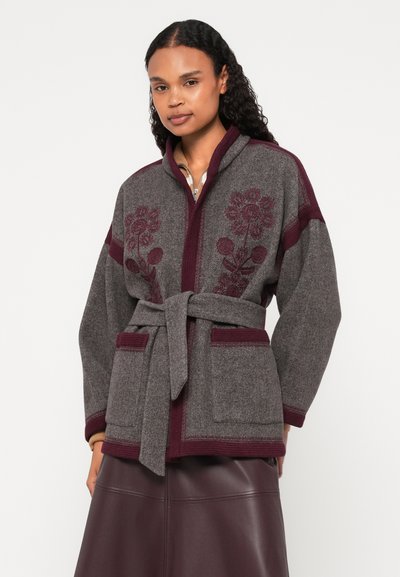 Γκρι μάλλινο μπουφάν με μαρουνί λεπτομέρειες, διαθέτει λουλουδάτα κεντήματα, μακριά μανίκια, τσέπες και ζώνη στη μέση.